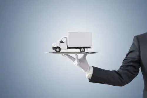 A businessman presenting a concept of logistics and delivery by holding a small truck on a tray, symbolizing efficient and controlled last mile delivery tracking services.