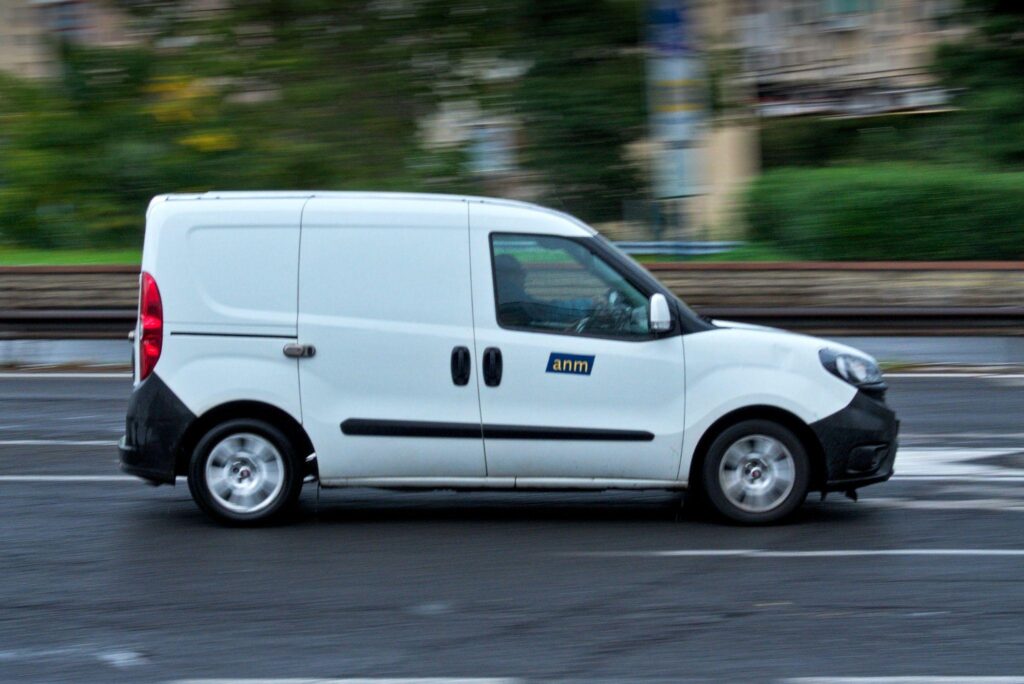 A closeup side shot of a white van speeding down the highway