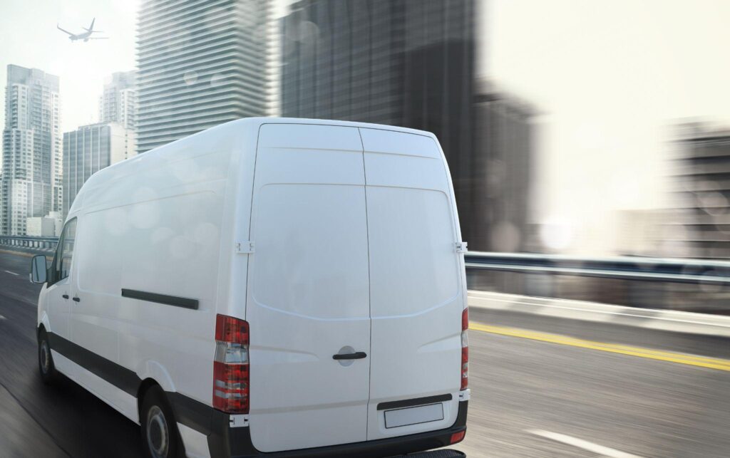 Closeup shot of the rear of a white van while it’s in motion