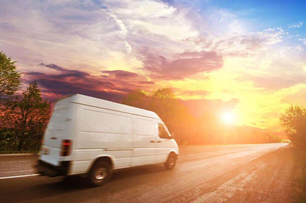 Cargo van driving at sunset, highlighting logistics optimization in last-mile delivery and customer satisfaction impact on logistics ROI