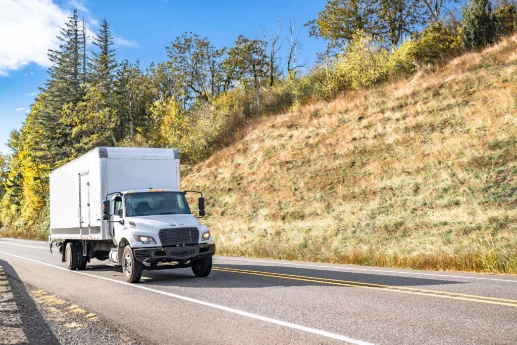 Mid-size box truck on a two-lane highway.