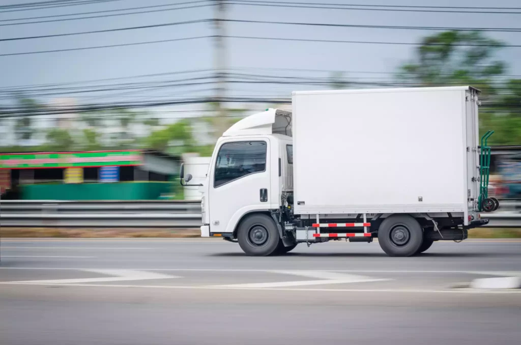 Delivery truck in traffic illustrating route optimization challenges and variability in logistics operations.