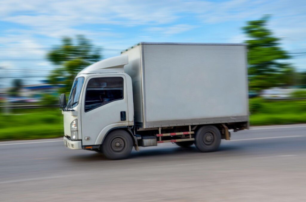 Small box truck in motion blur, showing dynamic route planning that adapts to traffic for delivery route optimization.