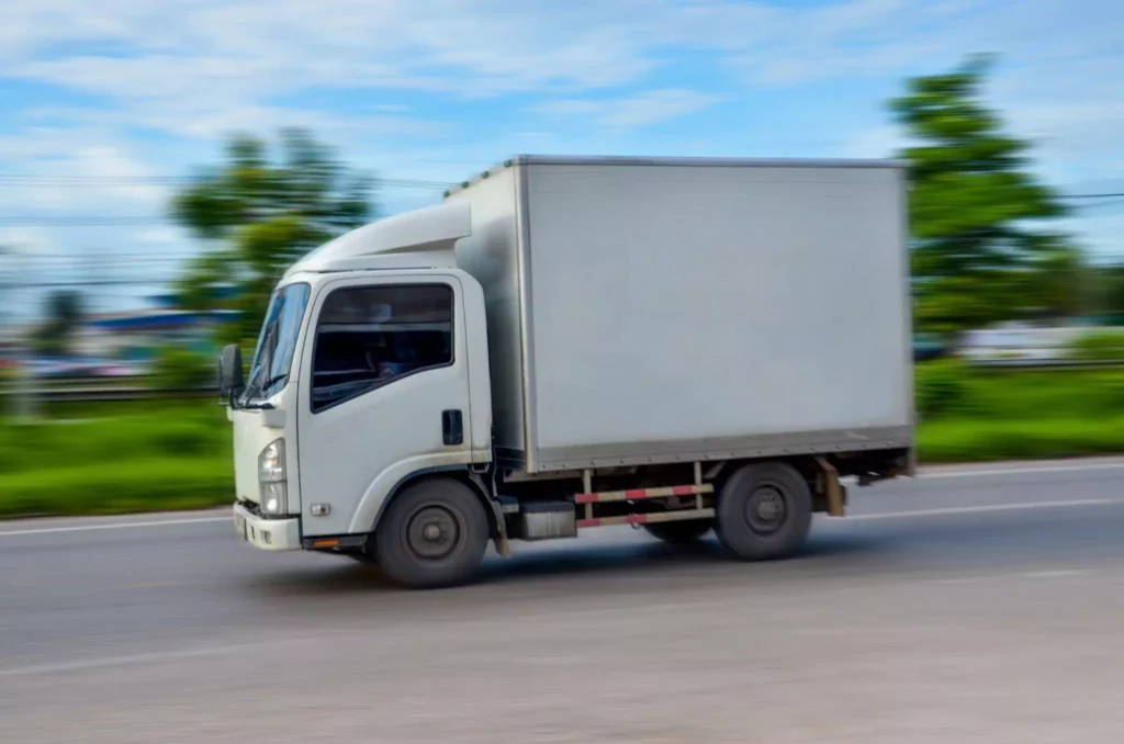 Small box truck in motion blur, showing dynamic route planning that adapts to traffic for delivery route optimization.