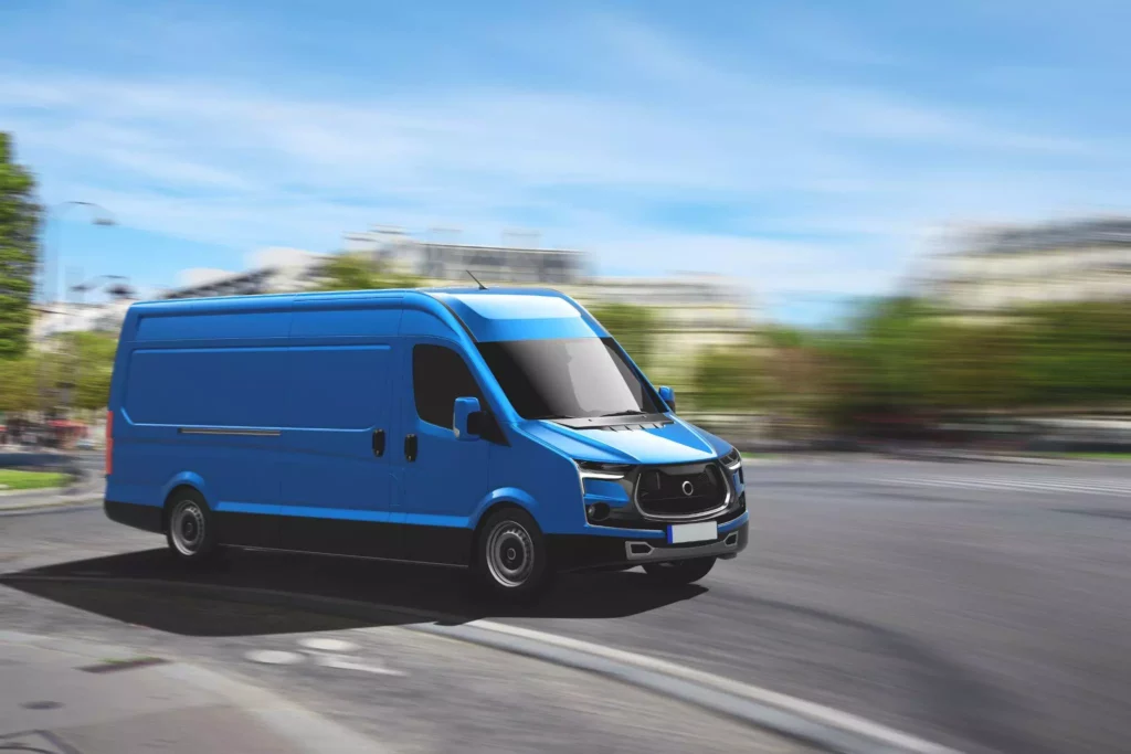 Blue urban delivery van turning through city streets, illustrating real-time tracking and proactive updates customers expect