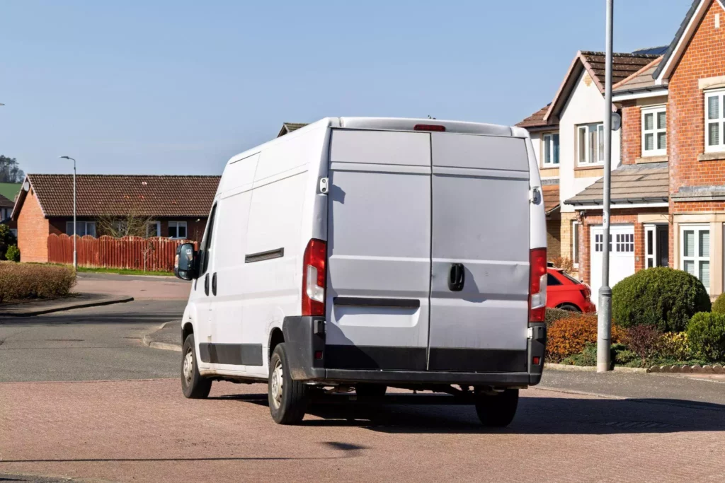 Rear shot of a parked white delivery van on a housing estate