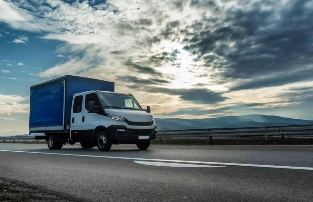 Low shot of a white box truck driving along the highway on a cloudy day