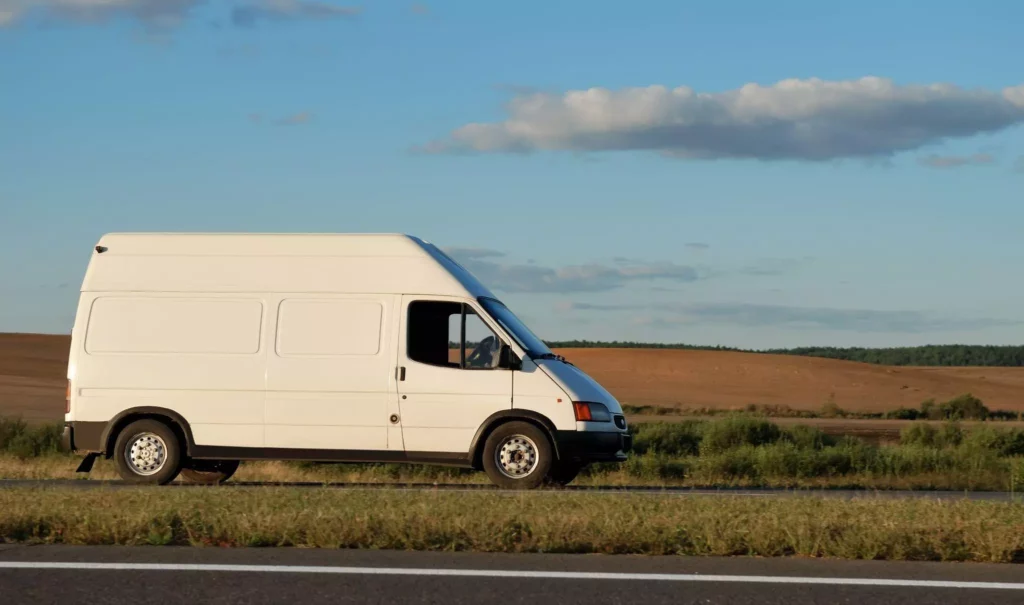 White van driving on the highway on a clear sky evening