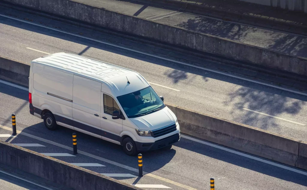 White cargo van on elevated roadway, illustrating last-mile delivery tracking and proactive exception management