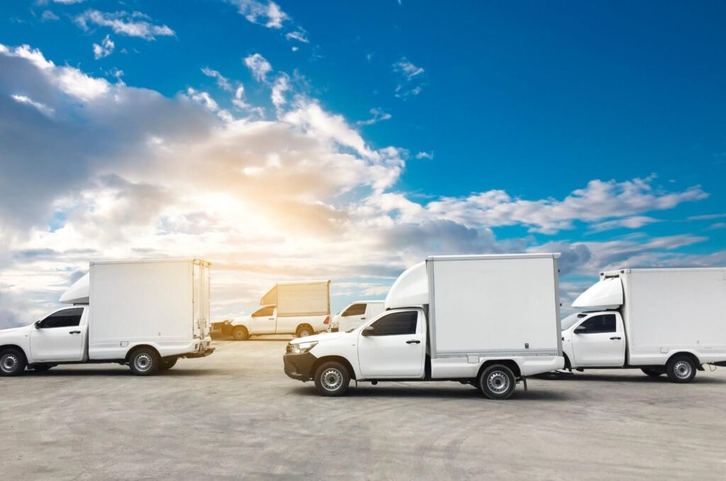 Lineup of white box trucks ready for dispatch.
