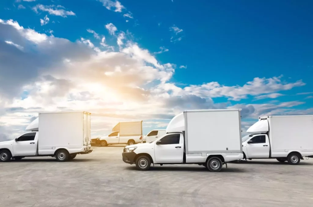 Lineup of white box trucks ready for dispatch.