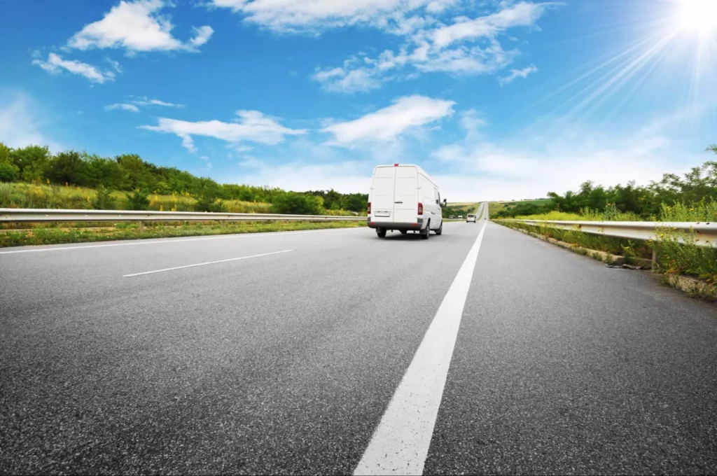 White delivery van continuing on an open highway after transparent delay communication