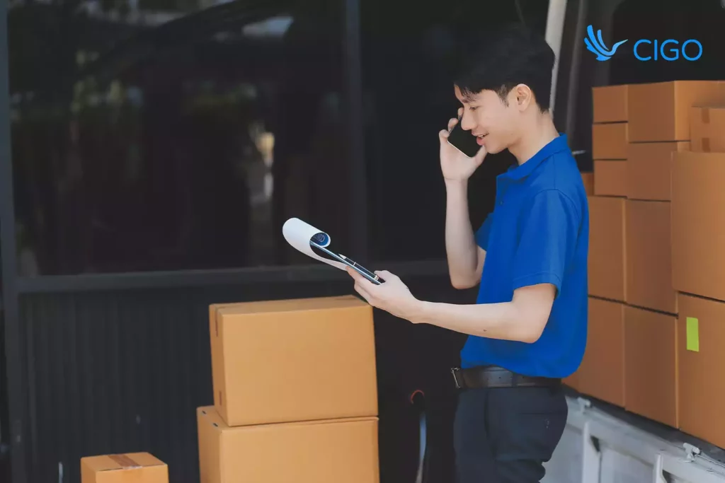 Dispatcher beside van checking the delivery list while talking about orders synced across systems