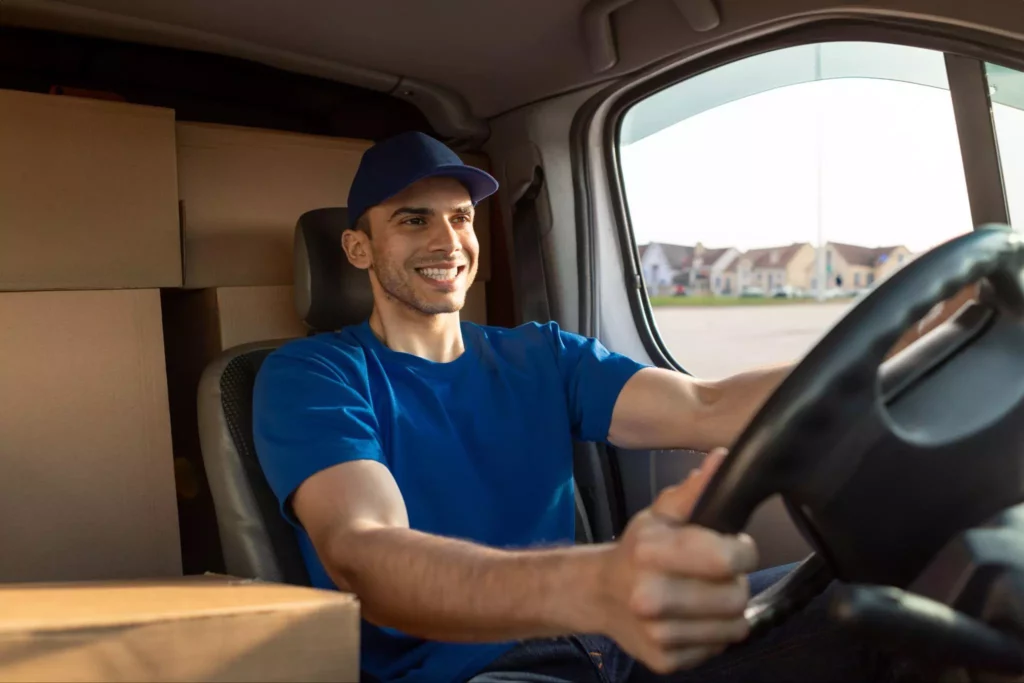 Smiling driver in a loaded van with real-time delivery updates synced across ERP and ecommerce