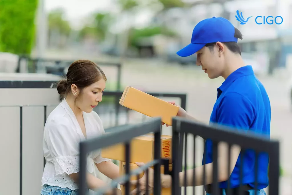 Delivery driver handing packages to customer at gate