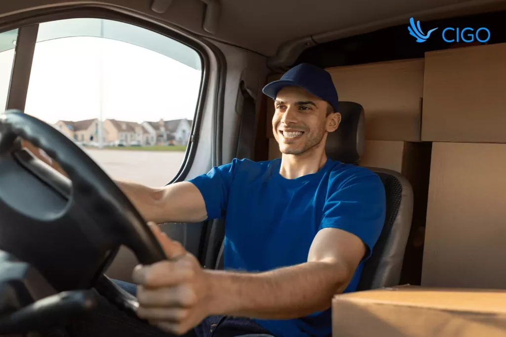 Smiling driver in a loaded van with real-time delivery updates synced across ERP and ecommerce