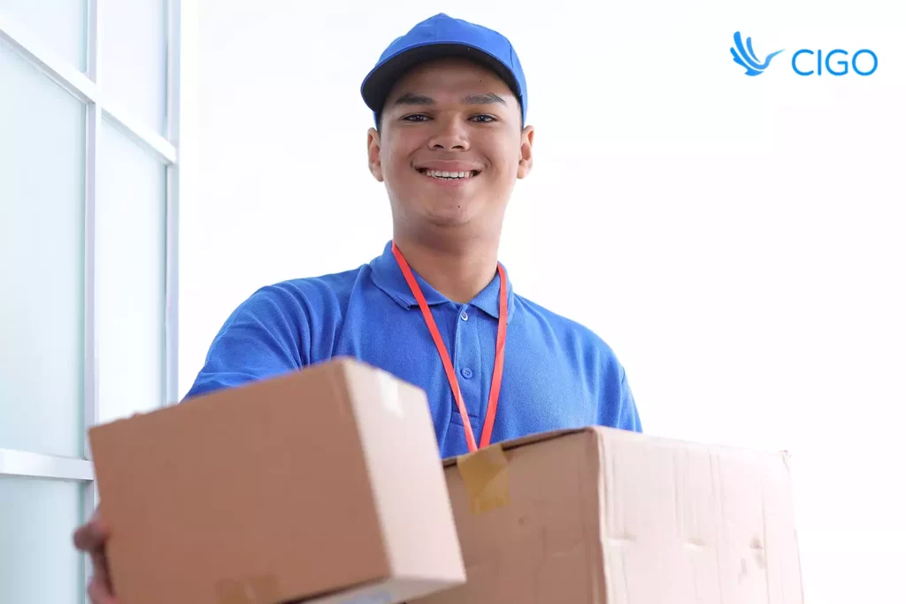 Delivery worker presenting boxes to the camera.