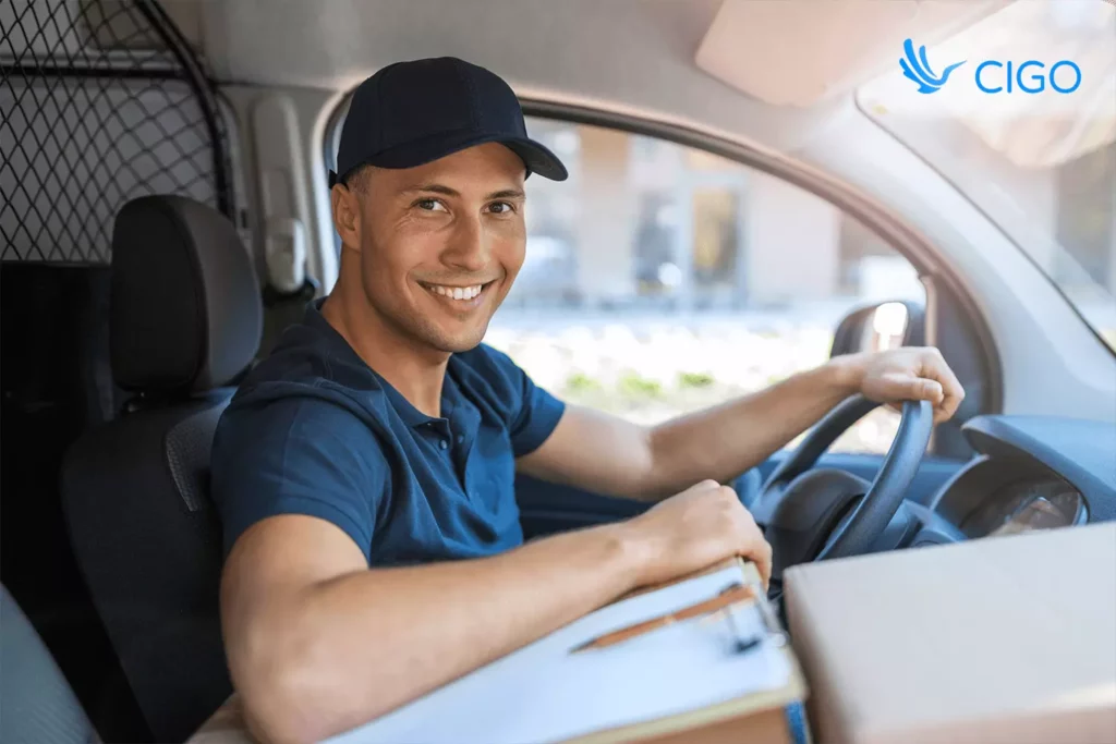 Smiling delivery driver in van ready for route, supported by real-time tracking and ETAs.