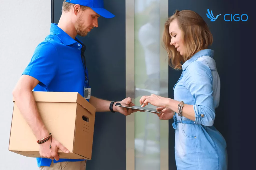Customer signing digital proof of delivery on tablet while courier updates status in real time.