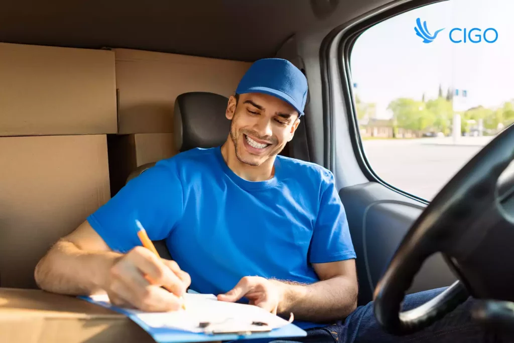 Delivery driver filling out route paperwork in van