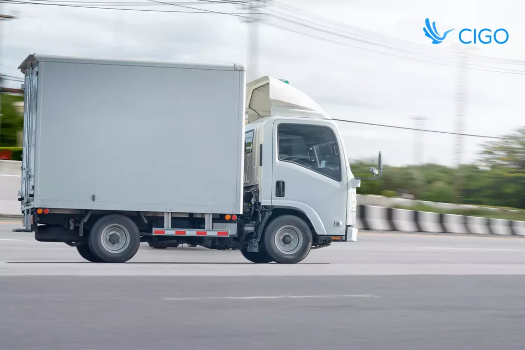 Box truck driving on city road symbolizing routes updated through real-time API data