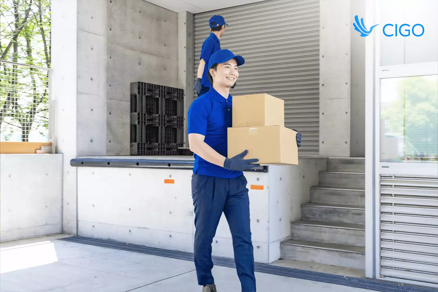Driver carrying boxes at delivery site, tied to real-time GPS tracking and proof of delivery.