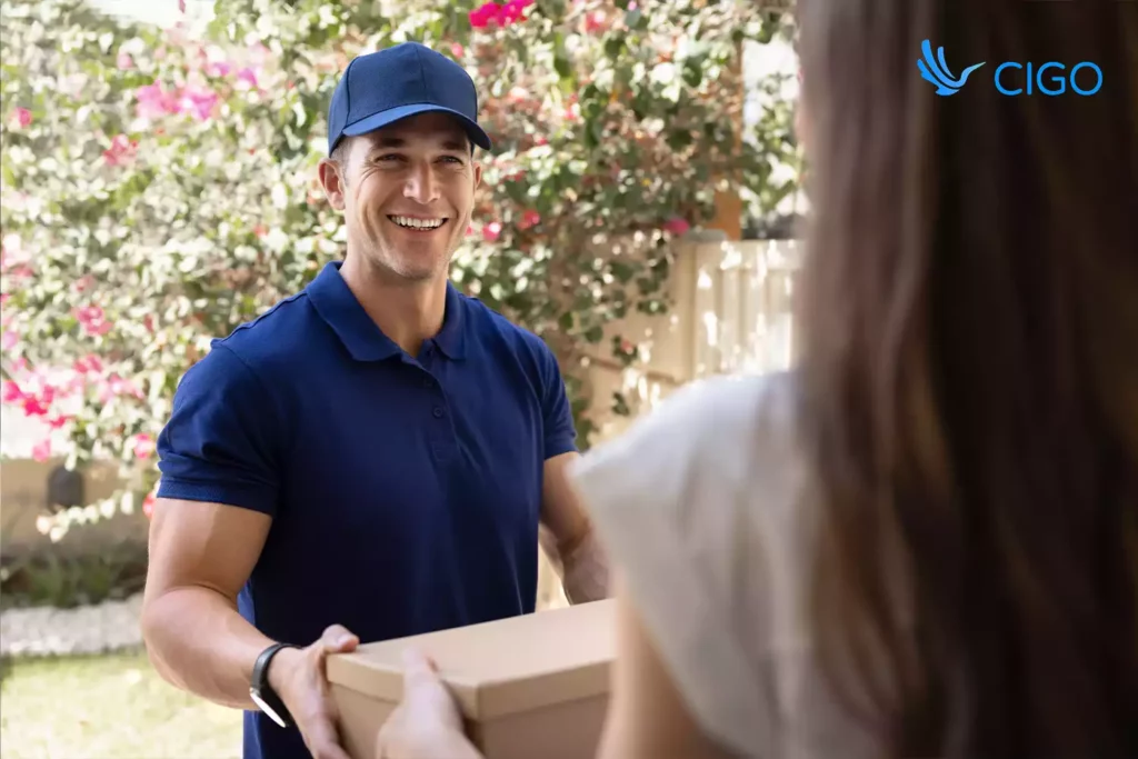 Smiling driver handing package to customer