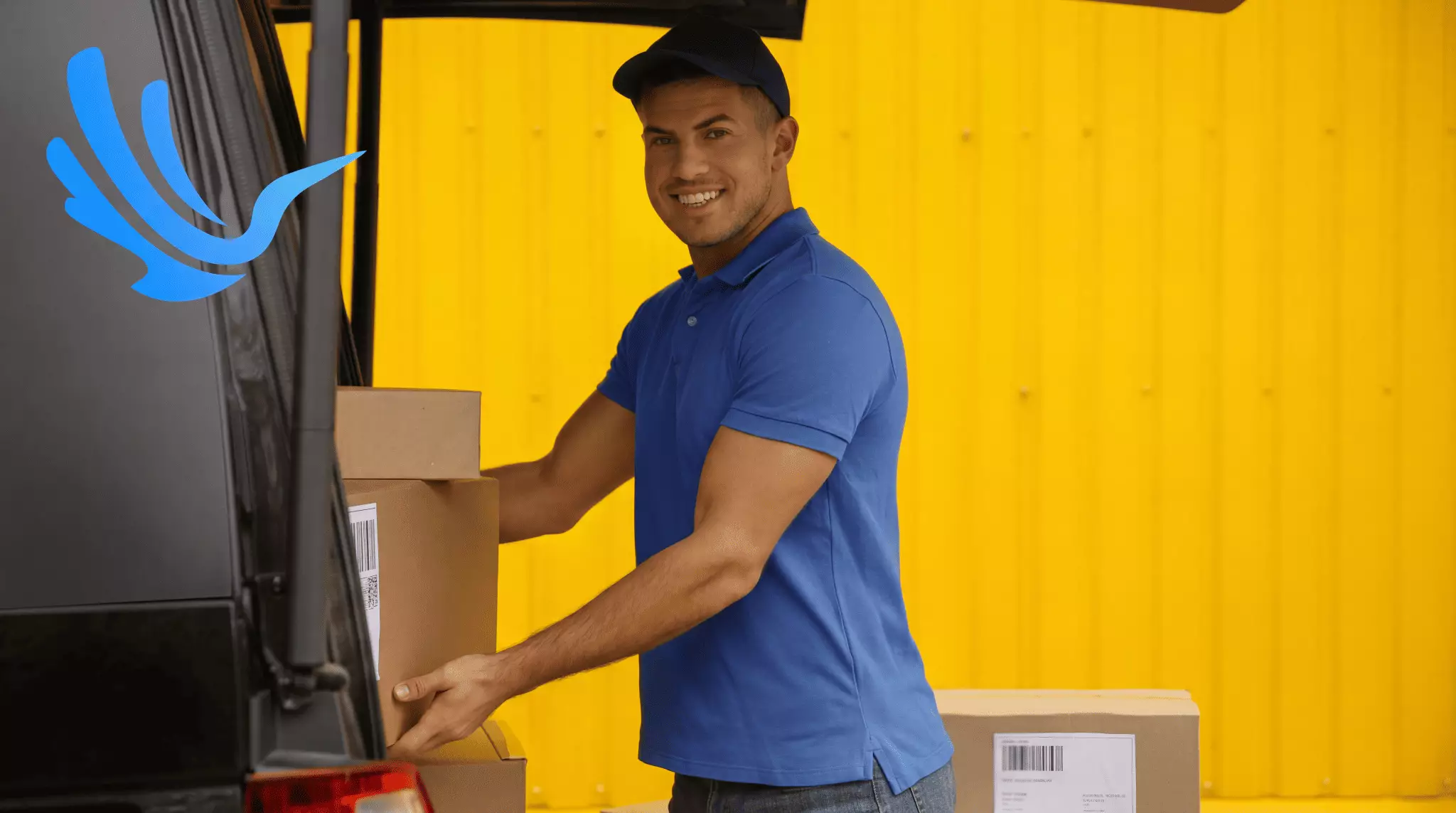 Delivery driver loading labelled packages into van at depot