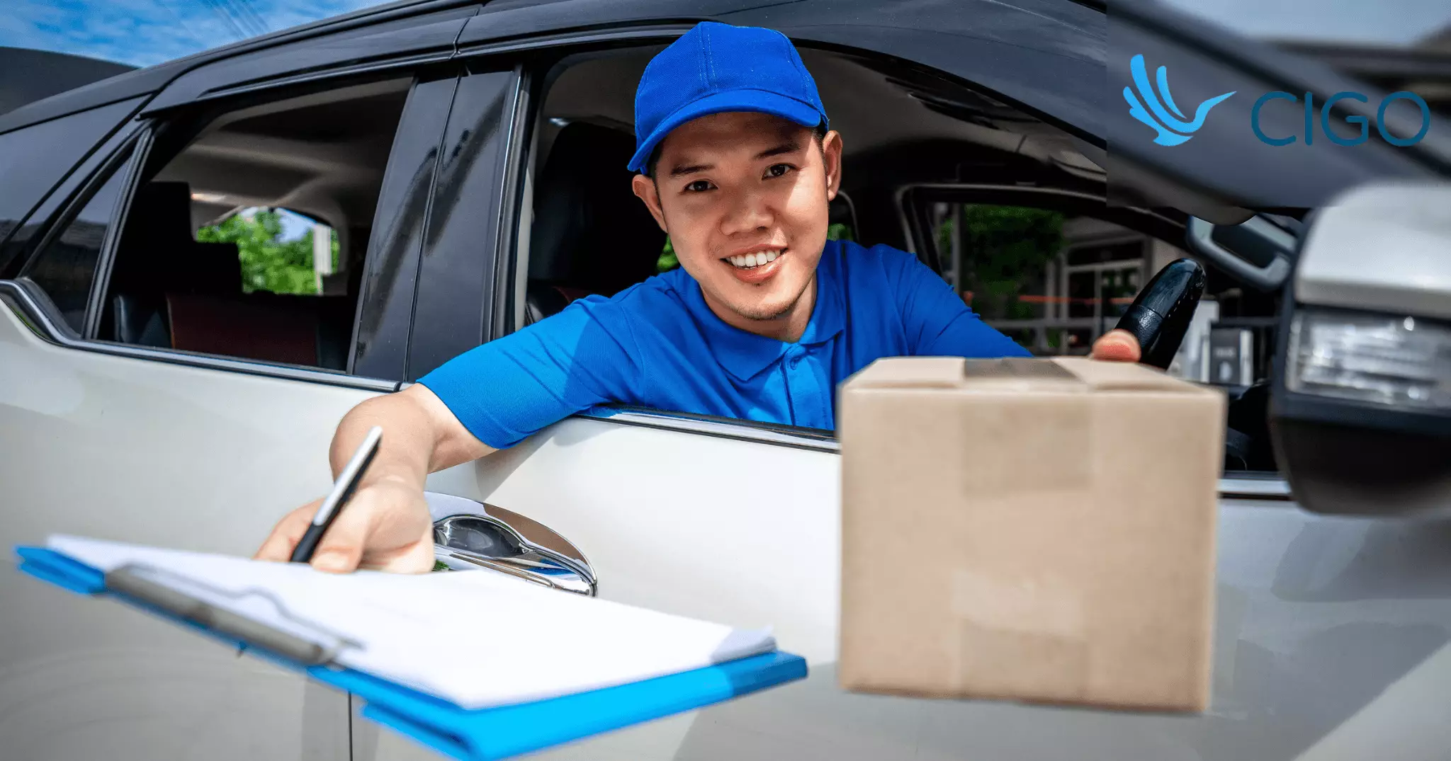 Delivery driver confirming stop with clipboard and package from vehicle