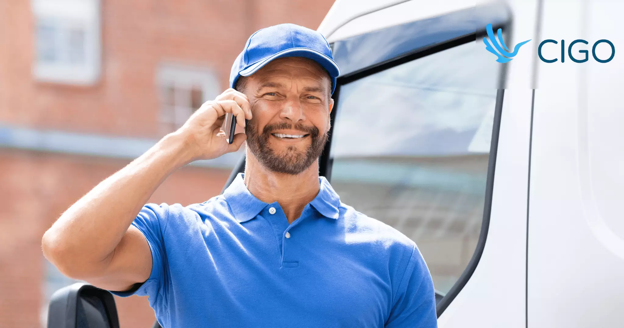Fleet delivery driver on phone call standing outside delivery van