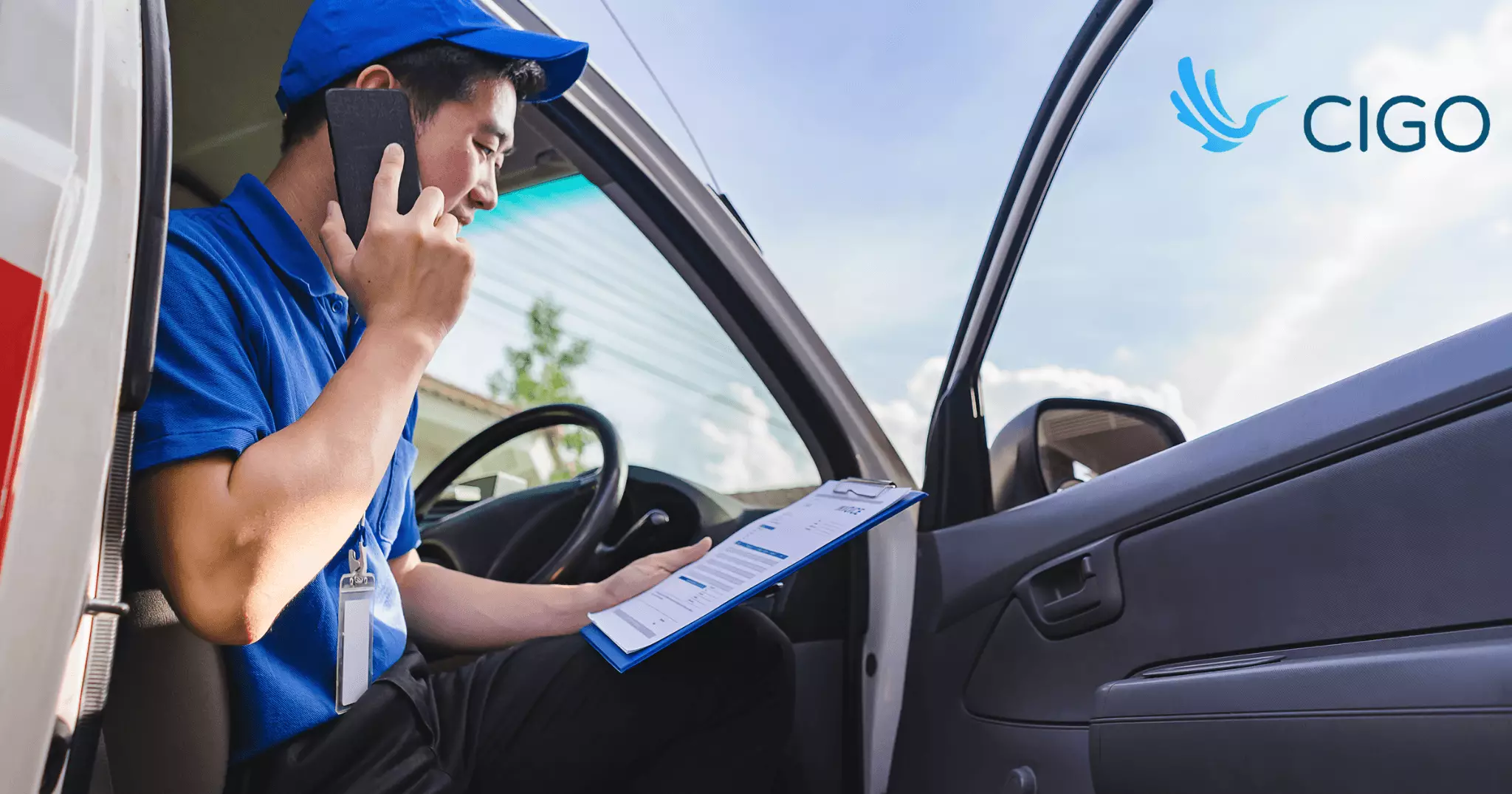 Delivery driver on phone reviewing delivery schedule in van