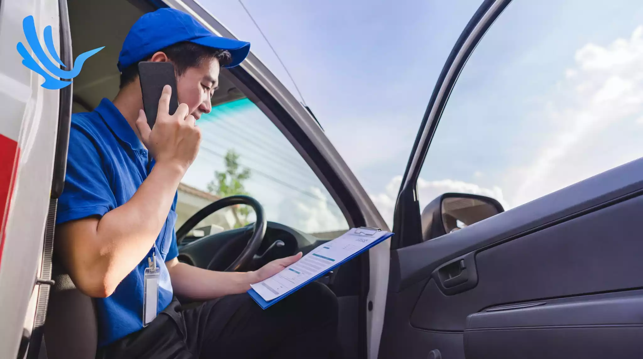 Delivery driver on phone reviewing delivery schedule in van