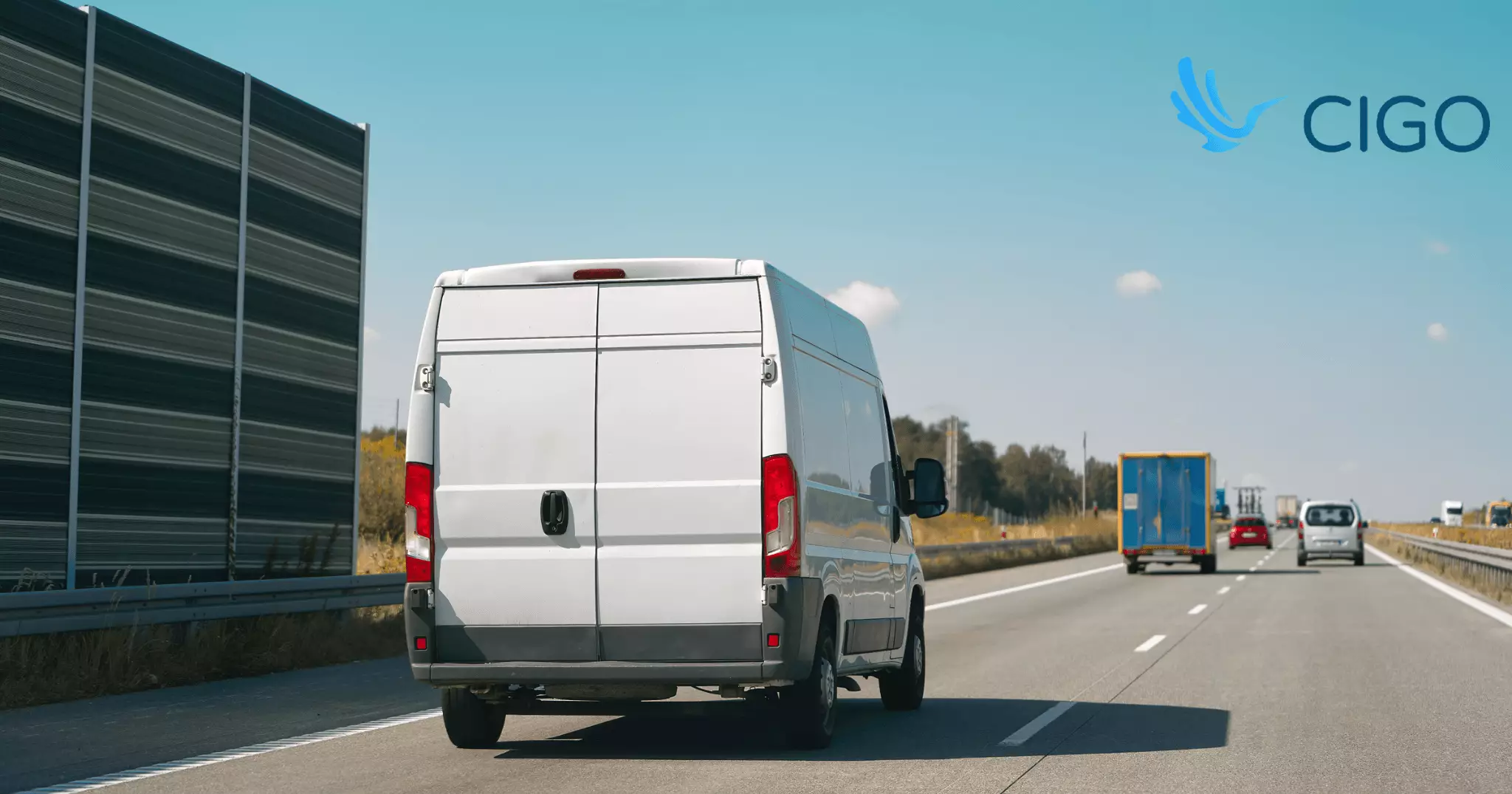 White delivery van driving on highway viewed from behind
