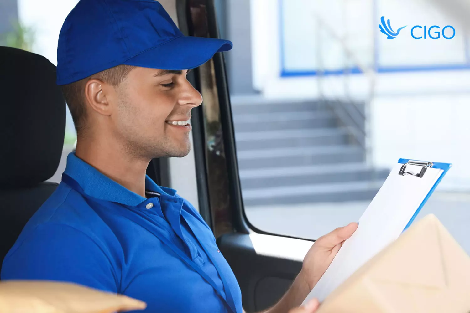 Delivery driver checking route clipboard with packages in van