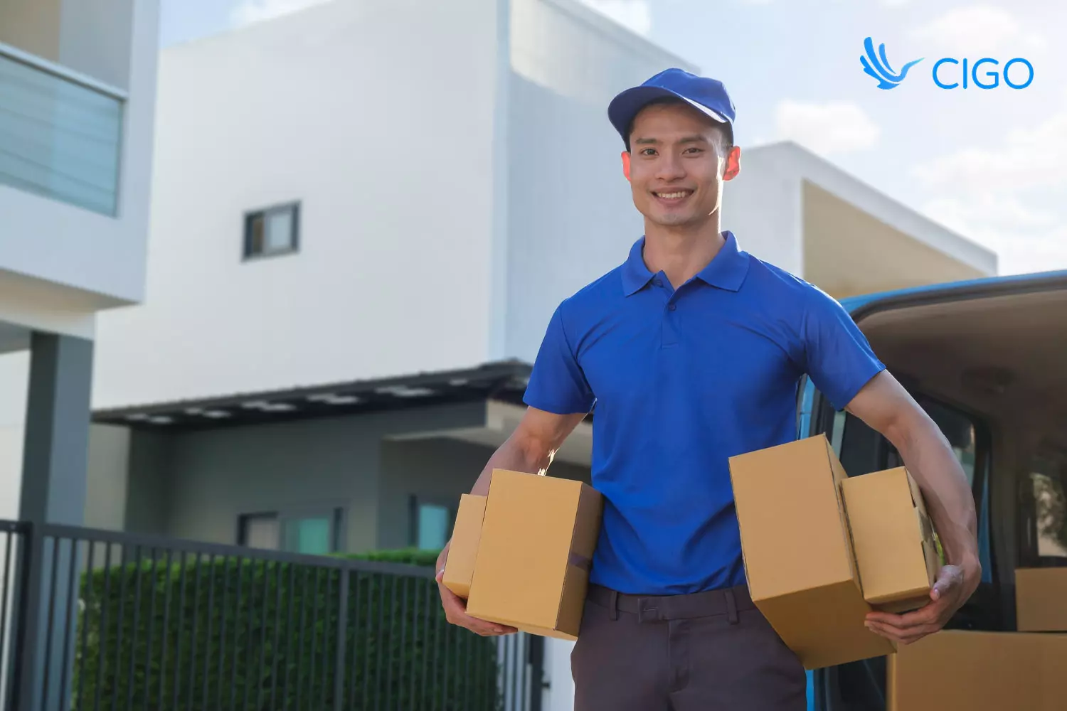 Delivery driver carrying packages at residential stop from van 