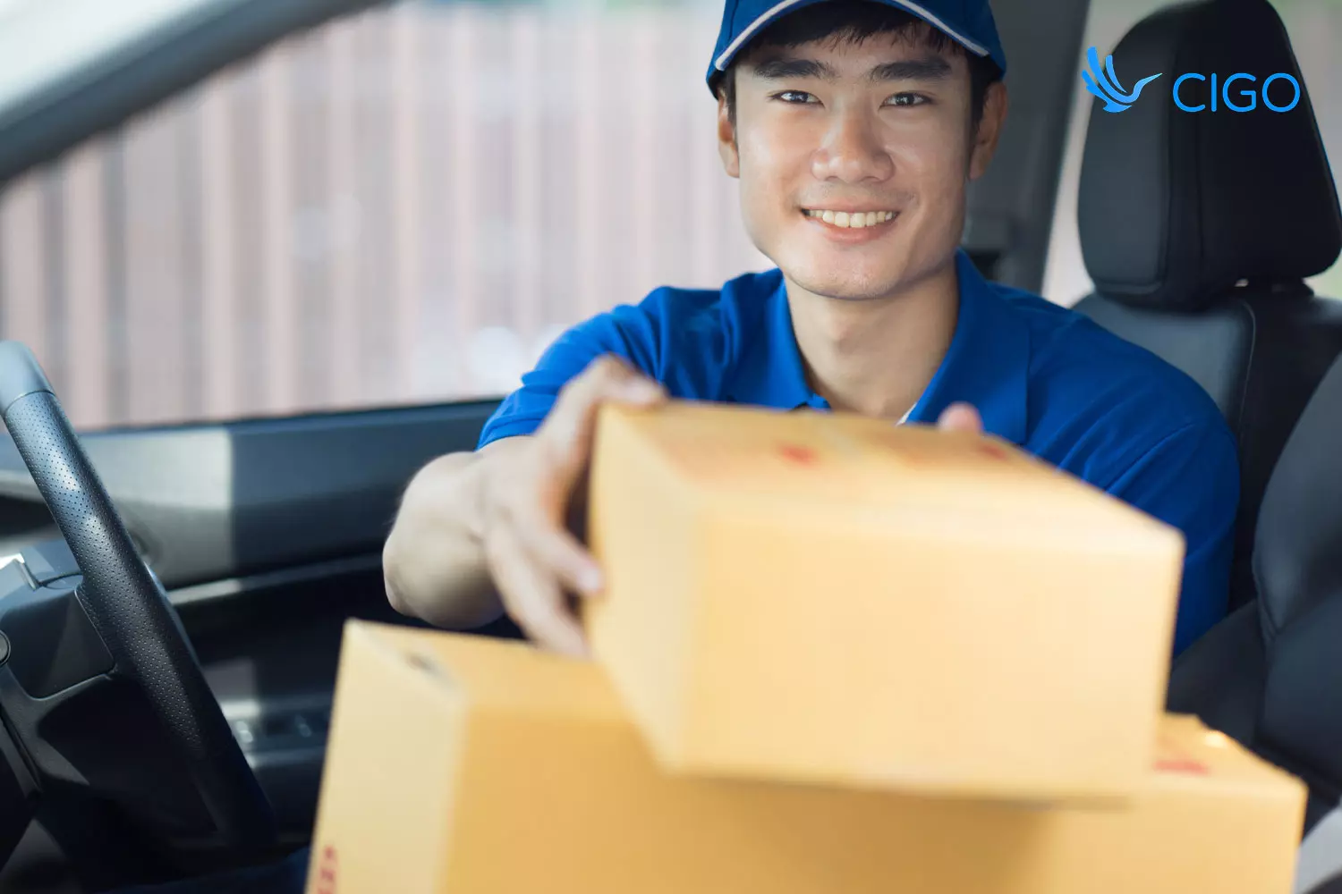 Smiling delivery driver handing packages from vehicle