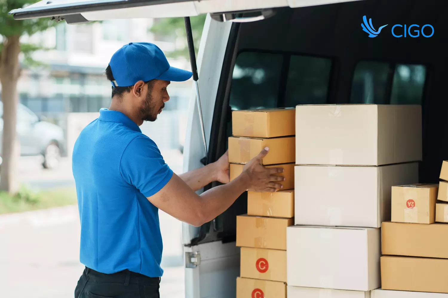 Delivery driver organizing stacked packages at open van