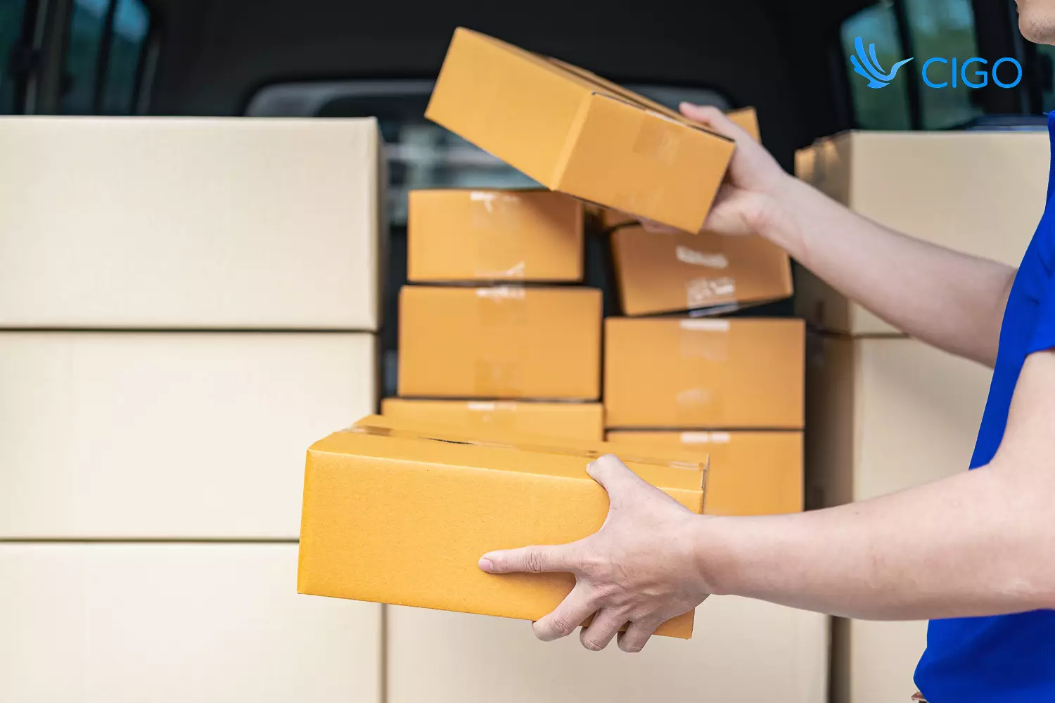 Delivery driver unloading multiple packages from van at stop