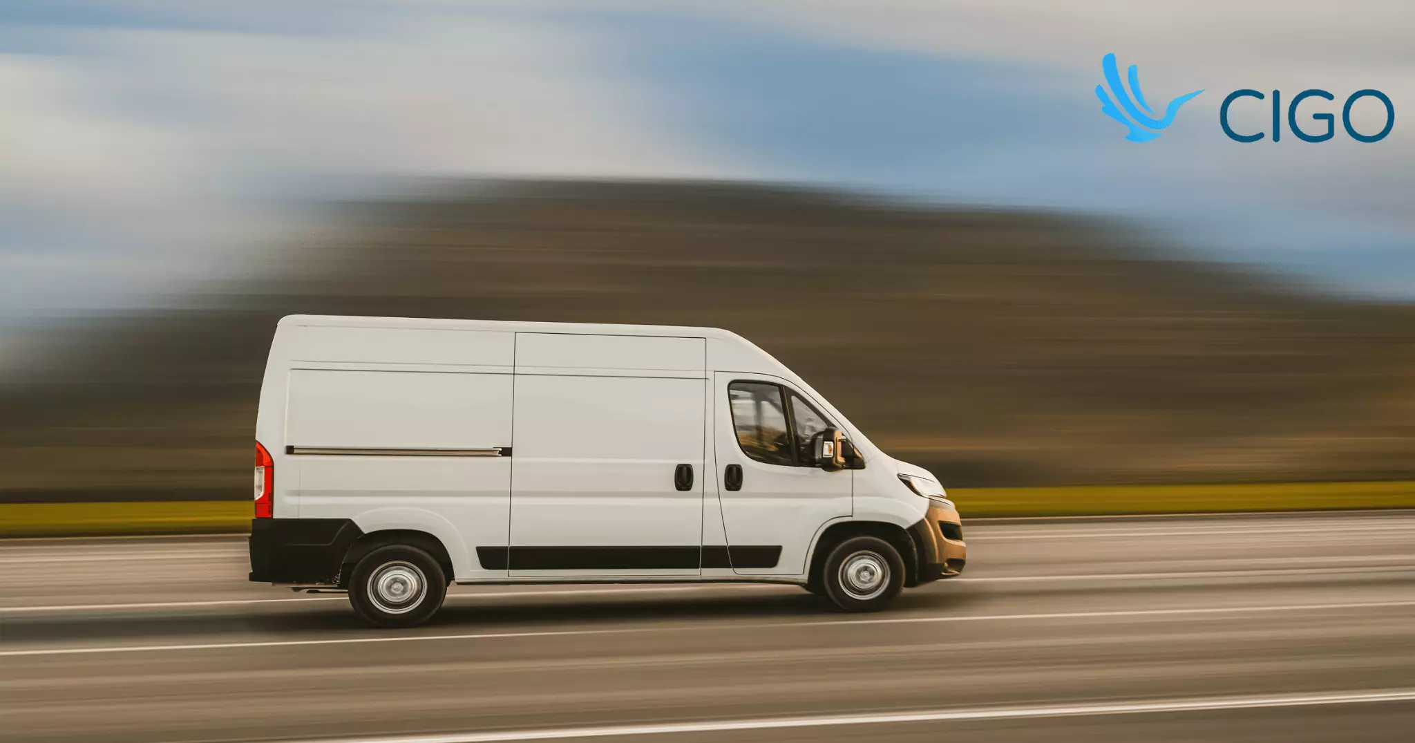 White cargo van speeding along open road in motion blur