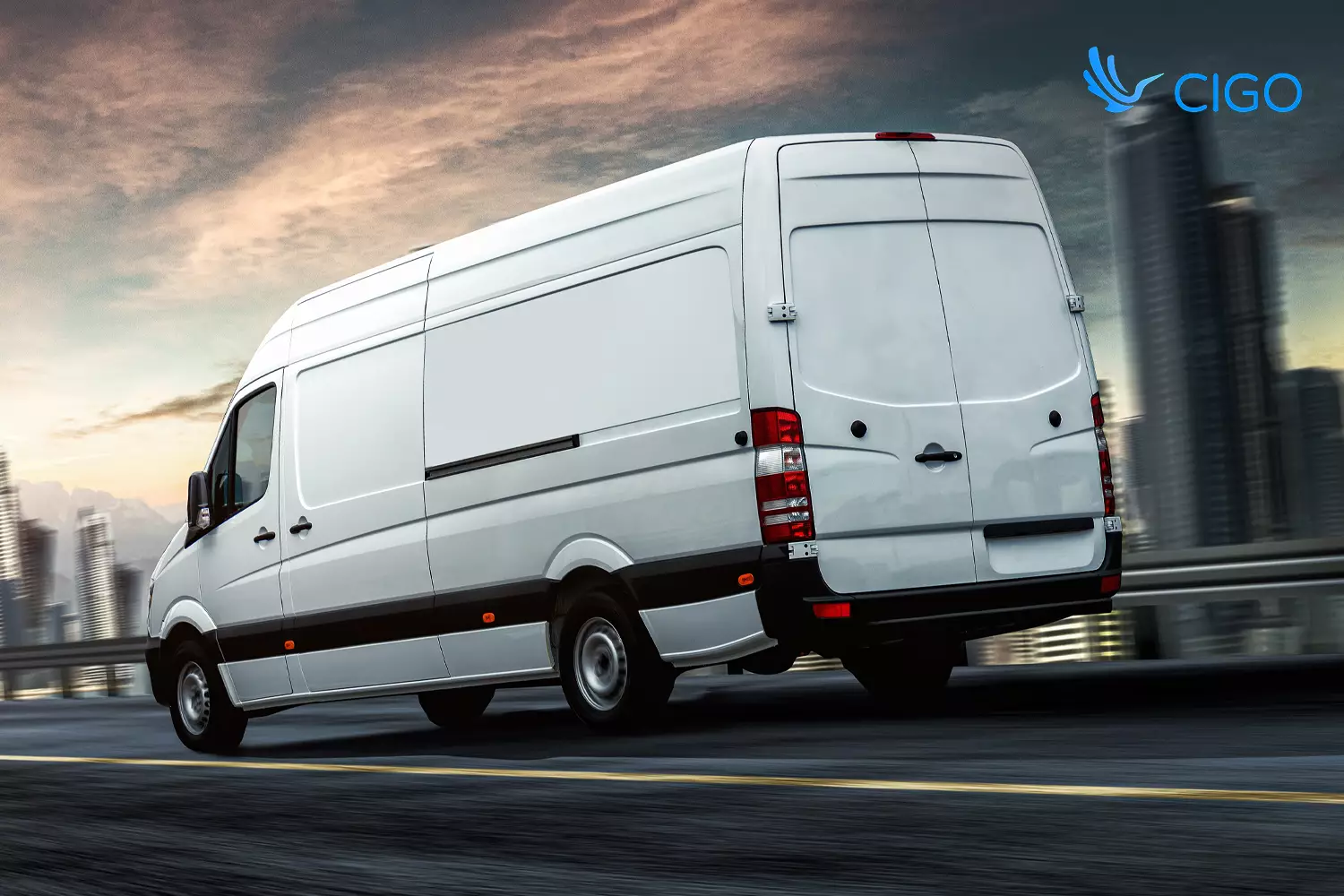 White fleet delivery van on highway route near city skyline