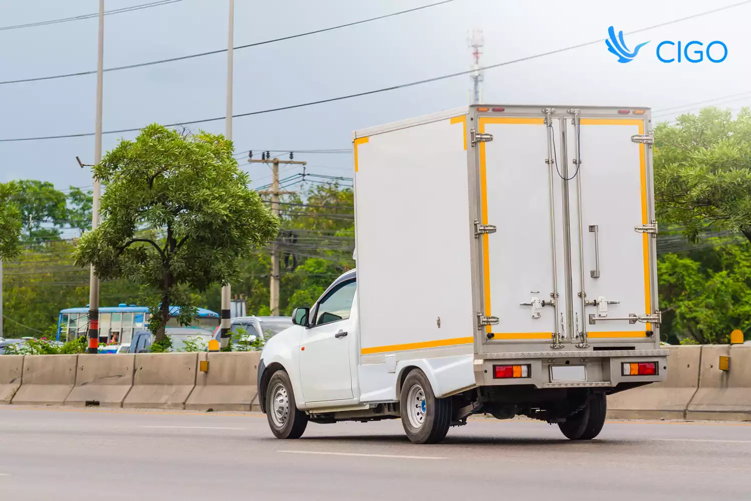 Small last-mile delivery truck driving on urban road 