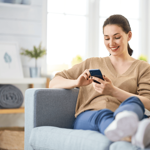 Happy customer sitting on couch after mattress delivery